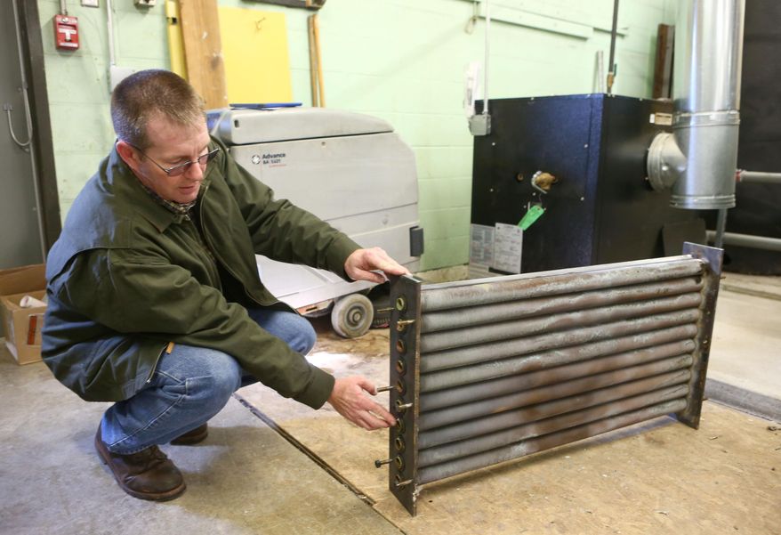 In this Tuesday, Feb. 23, 2016 photo, Jon Bearden, director of buildings and grounds at Eastern Howard School Corp., in Greentown, Ind., points out corroded pipes on the heat exchanger in the boiler room of the school. After having its water tested the school found elevated lead levels in the water coming from some of its sinks and drinking fountains and temporarily stopped its 1,500 students from using that water in February. (Kelly Lafferty Gerber/The Kokomo Tribune via AP) MANDATORY CREDIT