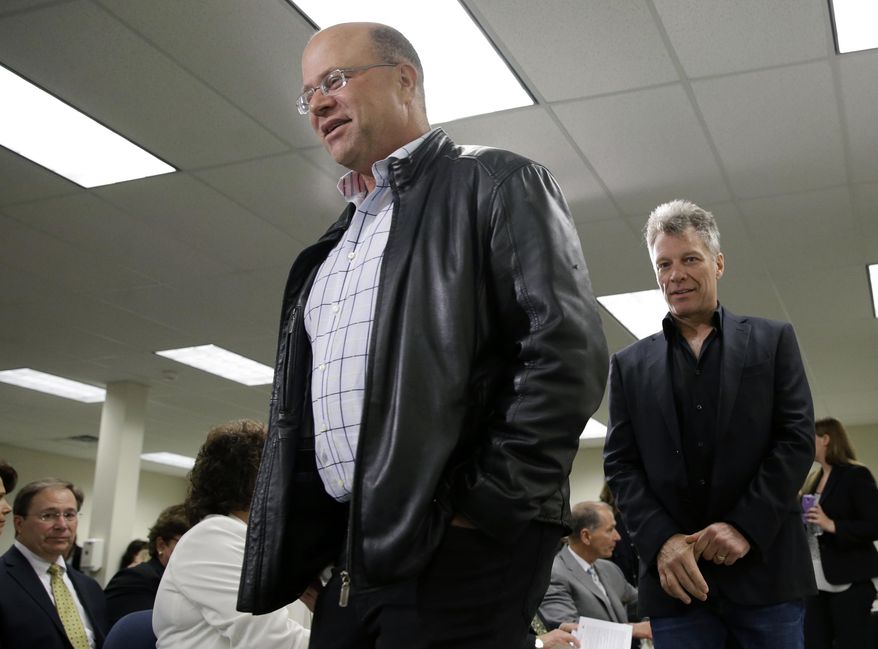 FILE - In this Tuesday, April 14, 2015 file photo, billionaire hedge fund manager David Tepper, left, and Rock and Roll star Jon Bon Jovi walk together at an event in Toms River, N.J. The spotlight turned to Tepper this week when legislative budget forecaster Frank Haines cited the billionaire's move to Florida as a potential factor in how much income tax revenue the state brings in. Income tax revenues make up the biggest share of cash in state coffers, and a shift in projections of as little as 1 percent amounts to about $100 million, forecasters say. (AP Photo/Mel Evans,file)