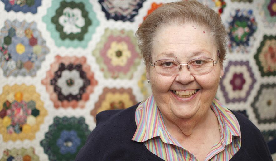 In this March 3, 2016 photo, Doyleen Workman Taylor poses in front of a quilt she made called Grandma's Treasures in Knoxville, Tenn. Taylor is state coordinator of Quilts of Valor which gives quilts to military veterans. (Rebecca D. Williams/Knoxville News Sentinel via AP) d.