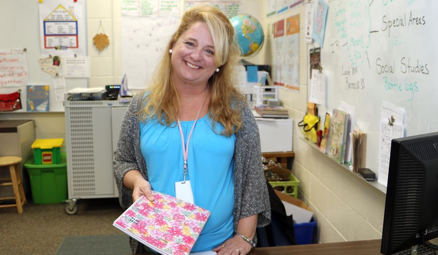 In this March 8 2016 photo, fourth-grade teacher Lori Clarke prepares for her students at Lonnie B. Nelson Elementary in Richland School District 2 in suburban Columbia, S.C. South Carolina's Career Changers loan-forgiveness program nearly covered the cost of Clarke's master's degree in education from the University of South Carolina. After graduating, $45,000 worth of loans were erased over three years of teaching at a high-poverty school in the Columbia area. She now works in a nearby school district. (AP Photo/Seanna M. Adcox)