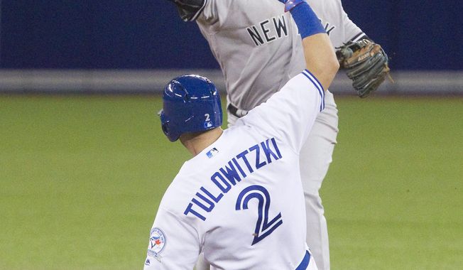 Toronto Blue Jays&#x27; Troy Tulowitzki is out on the force out at second base as New York Yankees&#x27; Didi Gregorius turns the double play on Chris Colabello during the third inning of a baseball game Tuesday, April 12, 2016, in Toronto. (Fred Thornhill/The Canadian Press via AP)