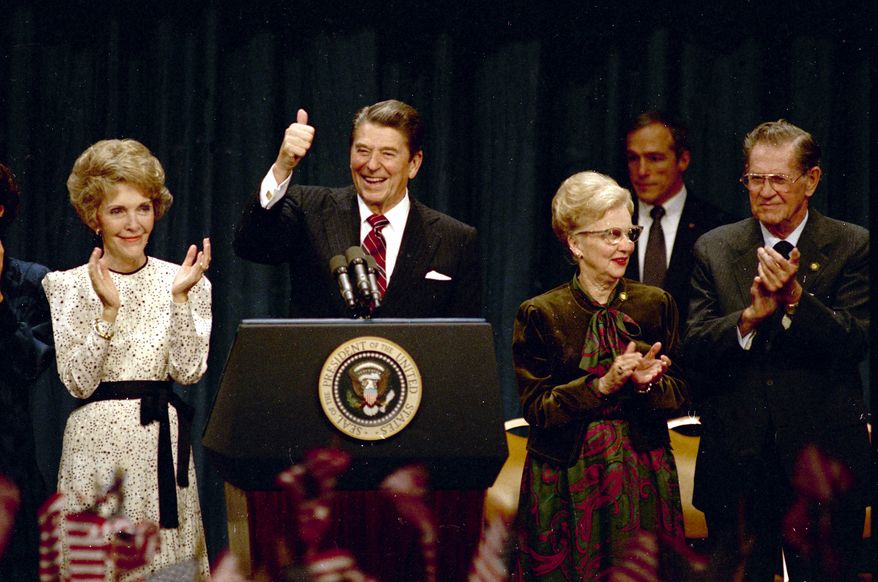 President Ronald Reagan gives a thumbs-up to supporters at the Century Plaza Hotel in Los Angeles as he celebrates his re-election, Nov. 6, 1984, with first lady Nancy Reagan at his side. Others are unidentified. (AP Photo)