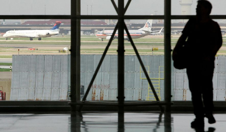 FILE - In this Aug. 26, 2008 file photo, a traveler is seen in Terminal C at Dallas Fort Worth International Airport as aircraft, rear, taxi along a runway in Grapevine, Texas. The government says more flights are arriving on time, airlines are canceling fewer flights, but passengers' complaints are still rising. The Department of Transportation said Wednesday, April 13, 2016 that 83.6 percent of flights on the leading airlines arrived on time in February. That's up from 81.3 percent in January and 72.8 percent the previous February. (AP Photo/Tony Gutierrez, file)