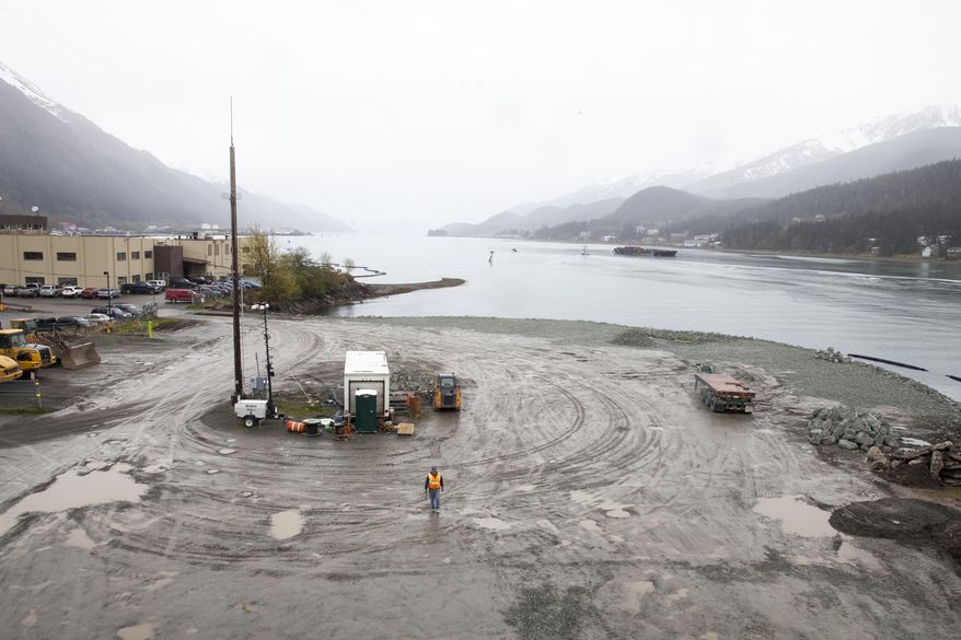 CORRECTS DATE FROM WEDNESDAY TO TUESDAY- A city worker walks along a site that will soon host a life-sized whale sculpture and bridge park project along the Gastineau Channel, Tuesday, April 12, 2016, in Juneau, Alaska. The city is being sued by a industry representative for 12 cruise lines which alleges that the city is misspending funds from a per-passenger tax on the whale project and others which do not directly benefit cruise passengers. (AP Photo/Rashah McChesney)