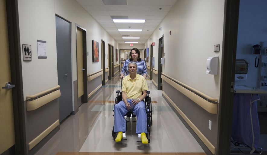 In this Feb. 18, 2016 photo, Mark Torbett and his wife, Regina, pose for a portrait at Northern Utah Rehabilitation Hospital in South Ogden, Utah. Torbett has filed a federal lawsuit against Ogden City, the Ogden Police Department and three officers. over what he says was excessive force and a violation of his Second Amendment rights by Ogden police officers during a Feb. 8 traffic stop. (Briana Scroggins/Standard-Examiner via AP) MANDATORY CREDIT