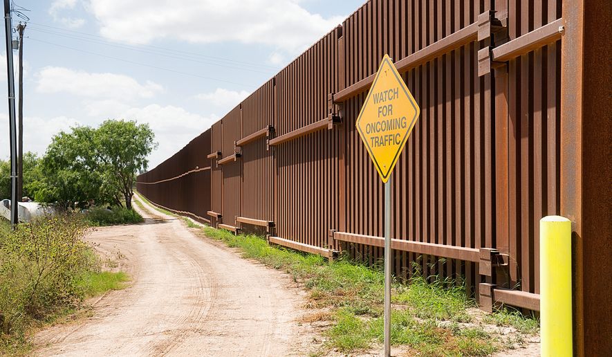 The fence marking the border between Mexico and the United States is photographed on Wednesday, July 16, 2014, in El Calaboz, Texas. (AP Photo/Valley Morning Star, David Pike) ** FILE **