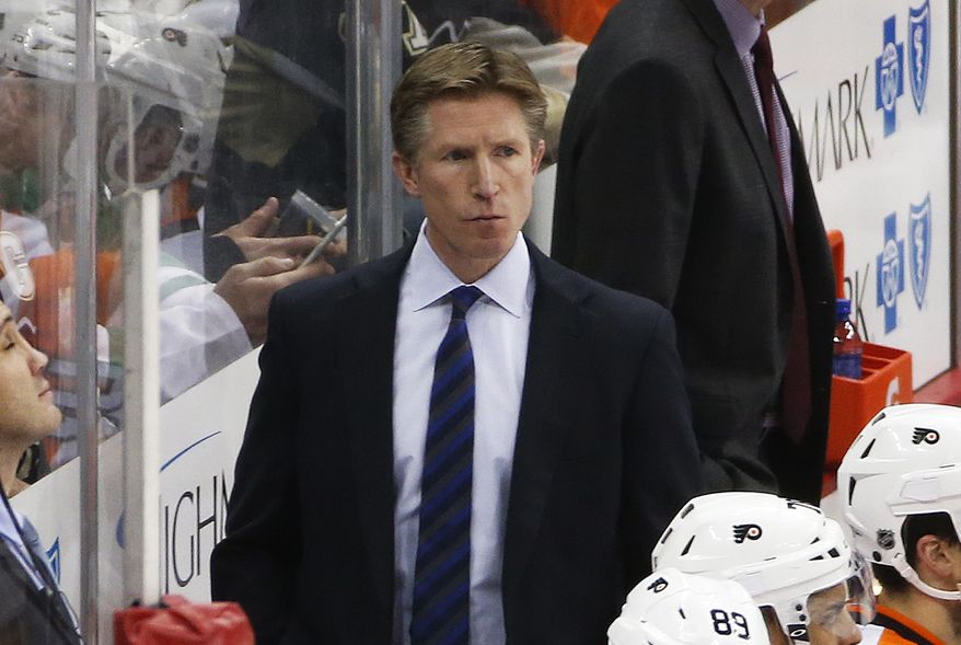 Philadelphia Flyers head coach Dave Hakstol, center, stands behind his bench during an NHL hockey game against the Pittsburgh Penguins in Pittsburgh, Thursday, Jan. 21, 2016. (AP Photo/Gene J. Puskar)