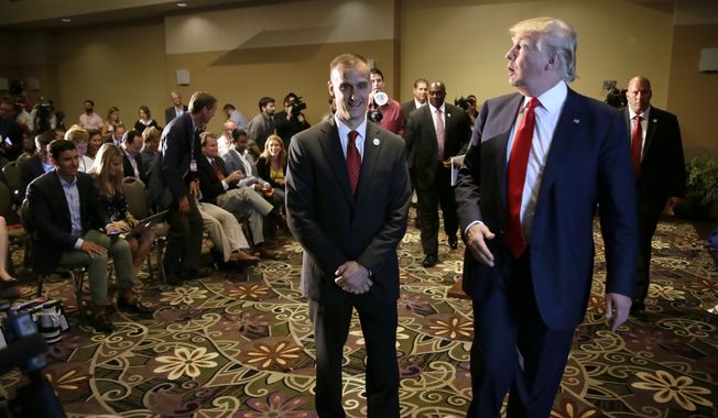 In this Aug. 25, 2015, file photo, Republican presidential candidate Donald Trump, right, walks with his campaign manager Corey Lewandowski after speaking at a news conference in Dubuque, Iowa. (AP Photo/Charlie Neibergall, File)