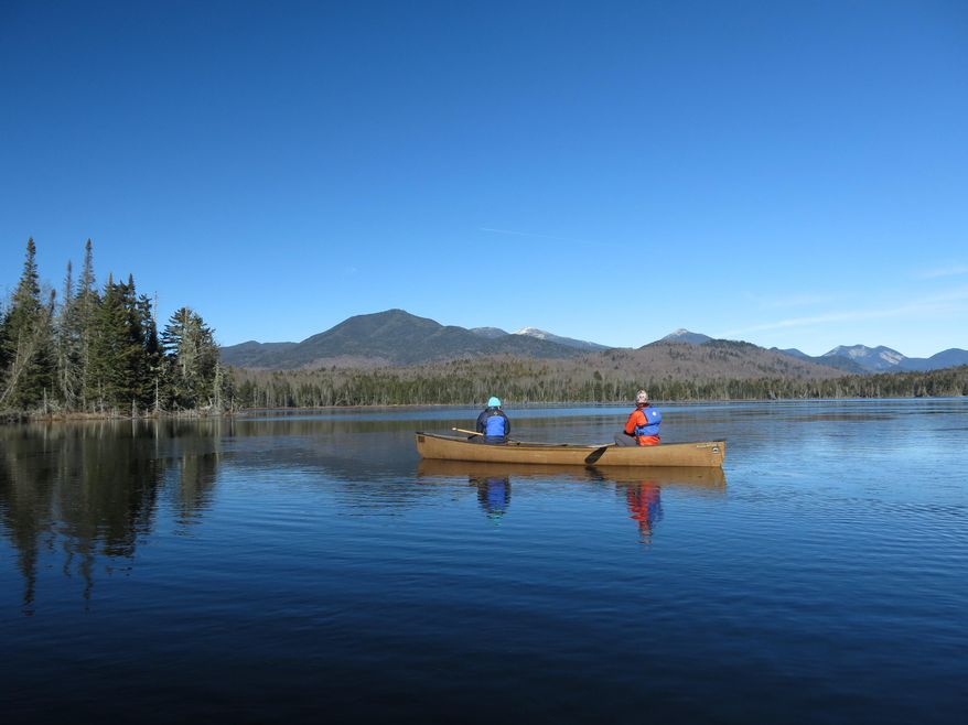 FILE - In this Nov. 17, 2015 file photo, Connie Prickett, right, of The Nature Conservancy, takes a guest on a canoe tour of Boreas Pond in North Hudson, N.Y. A deed filed with the Essex County clerk shows New York state has purchased the 22,000-acre Boreas Ponds tract in the Adirondacks for $14.5 million. The deed was made on March 16 between the state and The Nature Conservancy and filed on April 5. A conservancy spokeswoman confirmed the purchase Thursday, April 14, 2016. (AP Photo/Mary Esch)