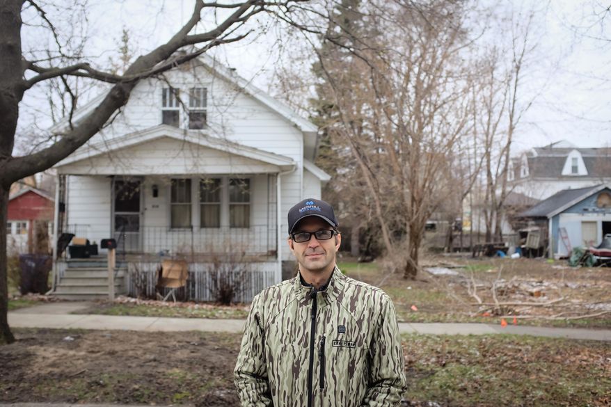 In this undated photo, Bay City Commissioner Chad Sibley, 8th Ward, poses in front of a foreclosed property in Bay City, Mich. The former Bay City commissioner who was convicted of a misdemeanor for putting a neighbor's lawn mower, grill and fire pit on the curb as part of an anti-blight effort is again seeking volunteers to help clean up the city. Chad Sibley told The Bay City Times he's organizing the second-annual cleanup day on April 23, 2016, to remove trash and rake yards of foreclosed properties that are usually off limits. (Andrew Dodson/The Bay City Times via AP) LOCAL TELEVISION OUT; LOCAL INTERNET OUT; MANDATORY CREDIT