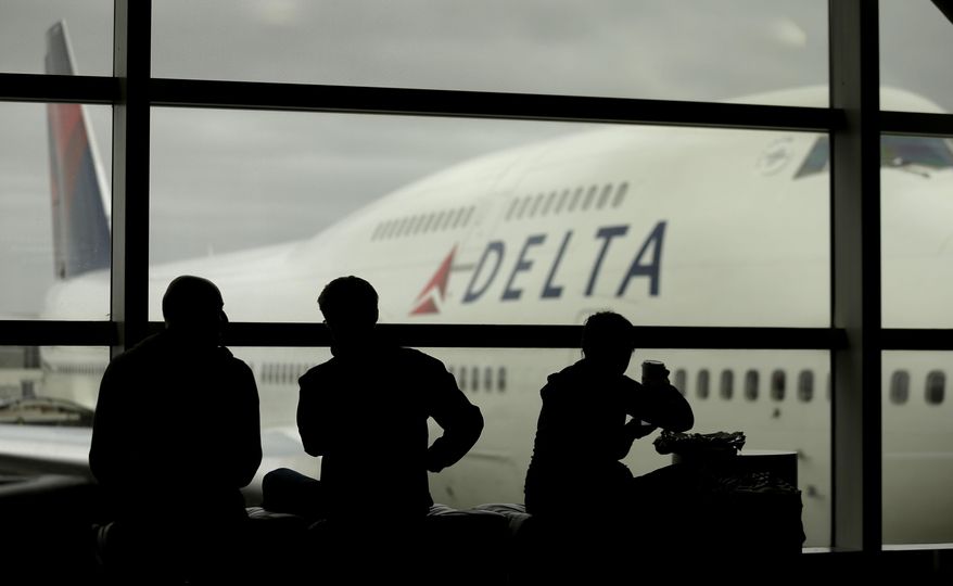 FILE - In this Monday, Oct. 29, 2012, file photo, travelers on Delta Air Lines wait for flights, in Detroit. Delta Air Lines Inc. said Thursday, April 14, 2016, it would drop the fee for U.S. consumers who buy tickets over the phone or at a ticket counter. The phone fee was $25 and the fee for a ticket bought at an airport or other ticket counter was $35. (AP Photo/Charlie Riedel, File)
