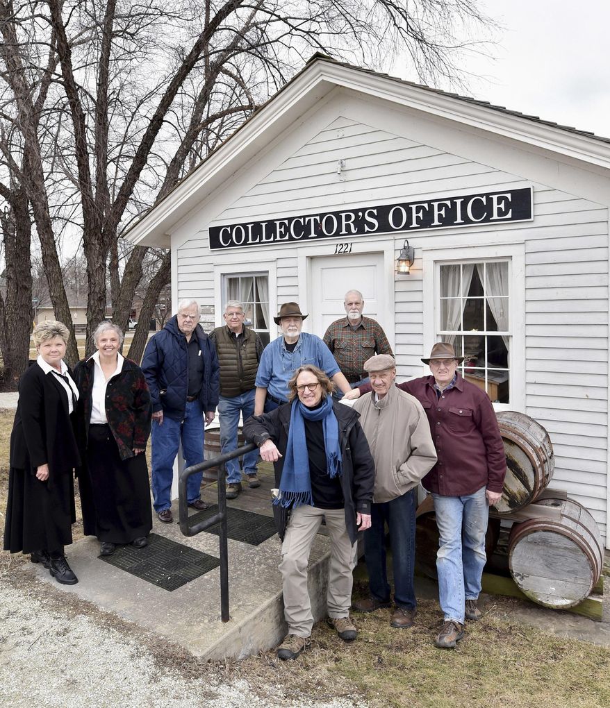 In this Feb. 29, 2016 photo, members of the Ottawa Canal Association, front row from left, Farley Andrews, Dave McBride and Arnie Bandstra and back row from left, Linda Roberts, Laura Dziedzic, Jim Mustered, Marty Ruhland, Stan Dziedzic and Bob Martyn pose for a photo in front of the toll collector's office in downtown Ottawa, Ill. The goal of group of vounteers is to re-water a section of the Illinois & Michigan Canal in downtown Ottawa and promote its tourism possibility. (Doug Larson/The Times via AP) MANDATORY CREDIT