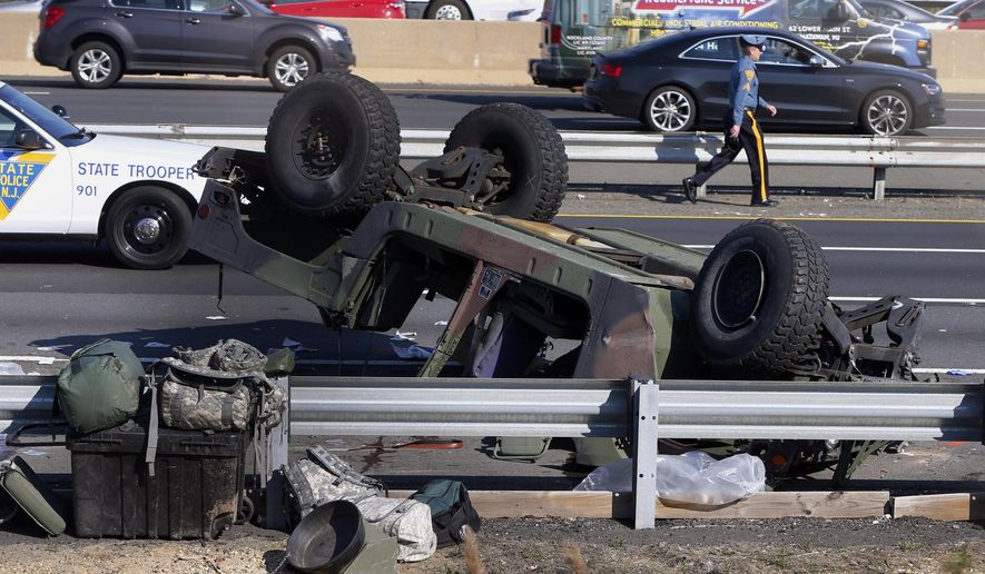 A state police trooper works the site where a Humvee overturned on the New Jersey Turnpike in South Brunswick, N.J., Thursday, April 14, 2016. State police said at least four soldiers were injured after the military vehicle overturned. (Thomas P. Costello/Home News Tribune via AP) MANDATORY CREDIT