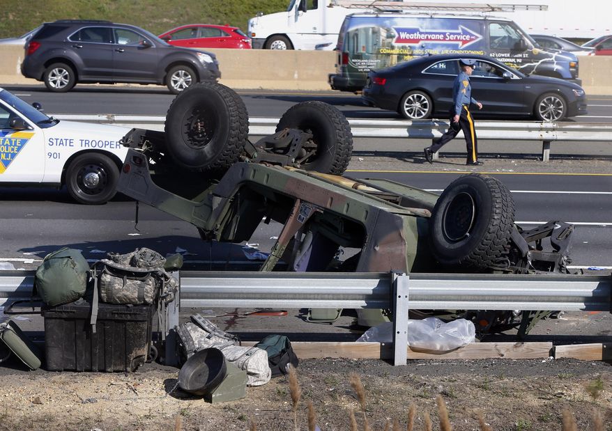 A state police trooper works the site where a Humvee overturned on the New Jersey Turnpike in South Brunswick, N.J., Thursday, April 14, 2016. State police said at least four soldiers were injured after the military vehicle overturned. (Thomas P. Costello/Home News Tribune via AP) MANDATORY CREDIT