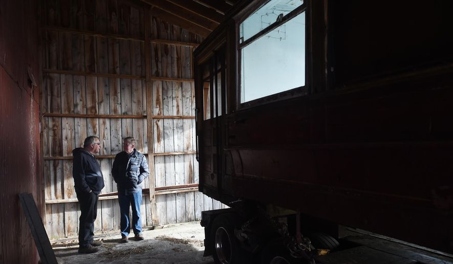 In this photo taken March 30, 2016, Jay Drouillard, left, talks with Grass Lake Supervisor Jim Stormont as a 1905 Chicago streetcar is delivered to the Scott Willis farm near Grass Lake, Mich. The interurban streetcar will be restored at the farm and will eventually be placed in the upcoming Lost Railway Museum. (J. Scott Park/Jackson Citizen Patriot via AP) LOCAL STATIONS OUT; LOCAL INTERNET OUT; MANDATORY CREDIT