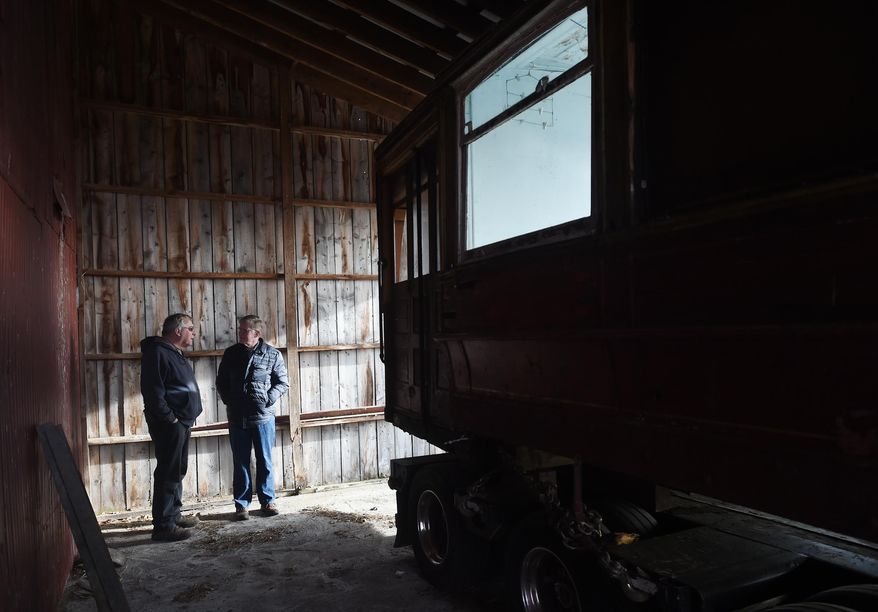 In this photo taken March 30, 2016, Jay Drouillard, left, talks with Grass Lake Supervisor Jim Stormont as a 1905 Chicago streetcar is delivered to the Scott Willis farm near Grass Lake, Mich. The interurban streetcar will be restored at the farm and will eventually be placed in the upcoming Lost Railway Museum. (J. Scott Park/Jackson Citizen Patriot via AP) LOCAL STATIONS OUT; LOCAL INTERNET OUT; MANDATORY CREDIT