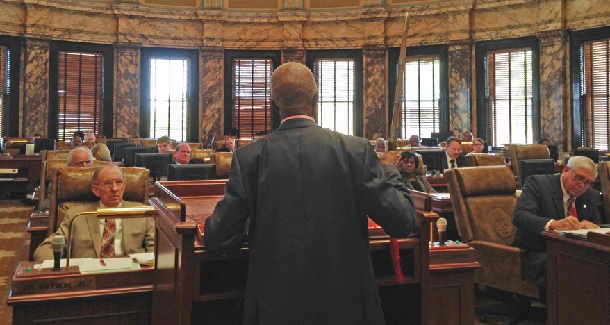 In this Tuesday, March 29, 2016 photo Sen. Hillman Frazier, D-Jackson, brandishes a sheathed sword during debate over House Bill 786, at the Capitol in Jackson, Miss. Frazier opposed the bill, which would grant immunity to trained church security teams that shoot people trying to commit violent crimes. Frazier said the bill went against Christian teaching, recounting the story of Jesus healing a servant of a high priest after a disciple cut off the servant's ear with a sword. (AP Photo/Jeff Amy)