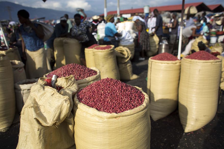 In this April 12, 2016 photo, sacs full of peanuts are displayed for sale in the Croix-des-Bossales market in Port-au-Prince, Haiti. Subsistence farmers in Haiti and economic development experts say they are dismayed by a planned influx of American-grown peanuts from a U.S. agricultural surplus that they fear could undercut a vital cash crop in the impoverished Caribbean nation. (AP Photo/Dieu Nalio Chery)