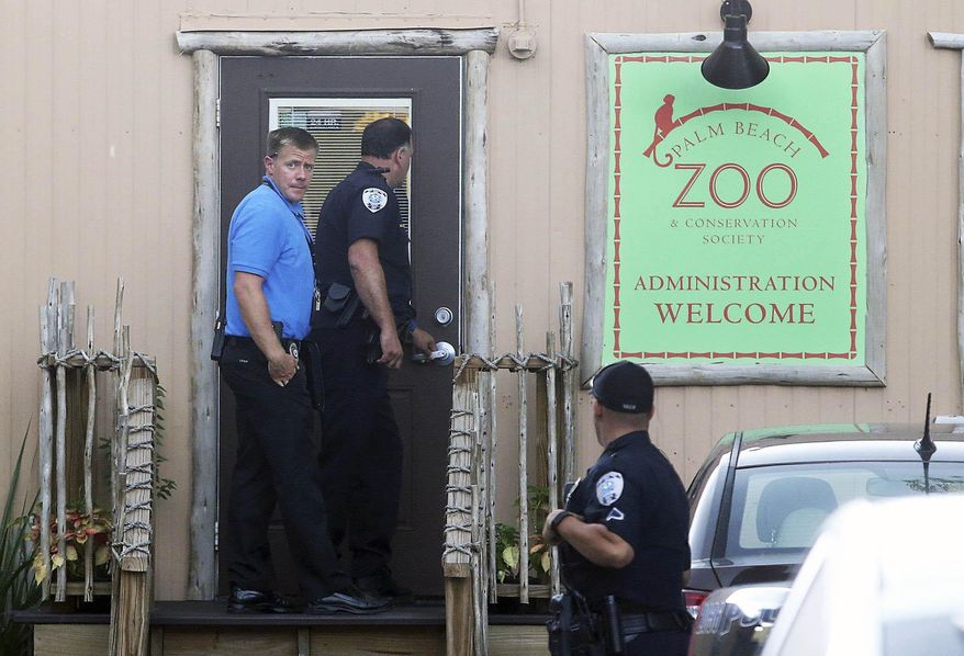 Police officers enter the administration building at the Palm Beach Zoo after zookeeper Stacey Konwiser died while being attacked by a tiger, Friday, April 15, 2016, in West Palm Beach, Fla. (Damon Higgins/Palm Beach Post via AP)