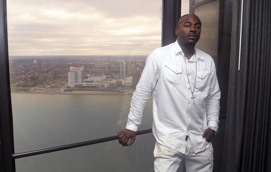 In a file photo from March 28, 2016, Robert Wilcoxson stands at his hotel window in Detroit, with a view of the city of Windsor, Ontario, behind him. Wilcoxson is one of two people freed by the North Carolina Innocence Inquiry Commission, and he received $5 million in compensation. (AP Photo/Jose Juarez)