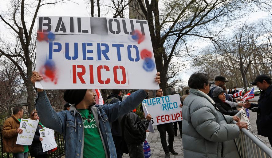 A demonstrator protests the Federal Reserve&#39;s failure to bail out Puerto Rico outside International House in New York on April 7, 2016. (Associated Press) **FILE**