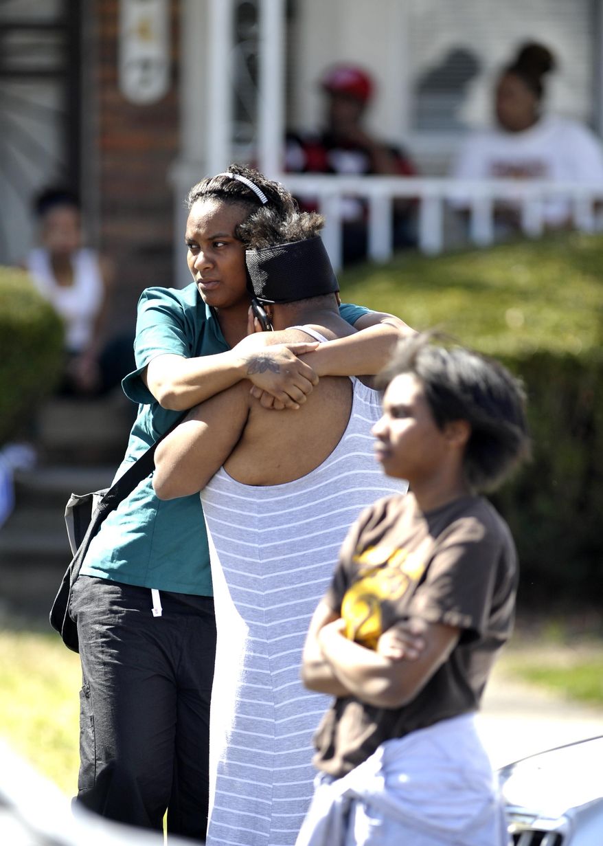 Two unidentified women hug each other near the shooting scene after a fatal shooting in the 18000 block of Winthrop, in Detroit, Saturday, April 16, 2016. Police say two men have been detained for questioning after a 6-month-old girl was fatally shot as she was with others in the yard outside a Detroit house. (Todd McInturf/Detroit News via AP) DETROIT FREE PRESS OUT; HUFFINGTON POST OUT; MANDATORY CREDIT