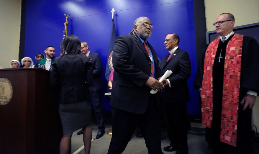 Death row exoneree Harold Wilson, thrid from right, leaves the podium after adressing a press conference at the General Assembly Building in Richmond, Va., Monday, April 18, 2016, with faith leaders opposed to the death penalty. The group of religious leaders is denouncing Virginia Gov. Terry McAuliffe's effort to shield the identities of pharmacies that supply drugs for executions. Two of those participating were Bishop Carroll Baltimore, Immediate National Past President, PNBC, second from right, and Rev. Max Blalock, William & Mary Wesley Foundation, right. (Bob Brown/Richmond Times-Dispatch via AP).