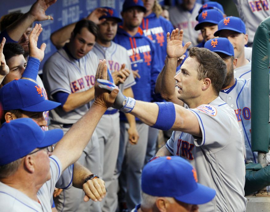 New York Mets' David Wright returns to high fives in the dugout after his solo homerun during the first inning of a baseball game against the Philadelphia Phillies Monday, April 18, 2016 in Philadelphia. (AP Photo/Tom Mihalek)