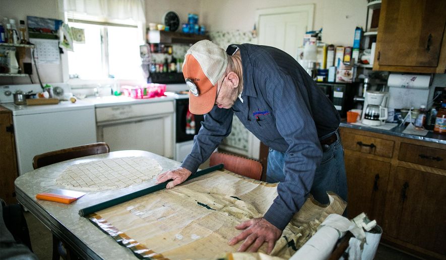 ADVANCE FOR SATURDAY, APRIL 23 AND THEREAFTER - In an April 13, 2016 photo, Newport Cemetery caretaker Charlie Wentz looks for a name on one of the old maps of the cemetery that often were hand-drawn on the backs of window blinds. The Newport Cemetery recently digitized their grave records. (Sean Simmers/PennLive.com via AP)