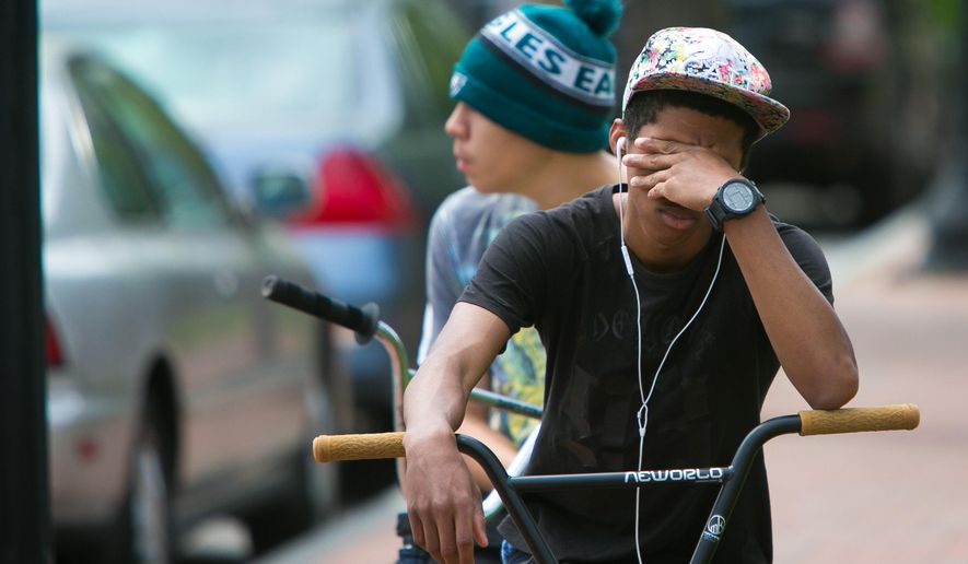 A student cries in front of Howard High School of Technology on Thursday, April 21, 2016 in Wilmington, Del. A 16-year-old sophomore died Thursday following a fight in a Delaware high school girl's restroom, city officials said. (Suchat Pederson/The Wilmington News-Journal via AP) NO SALES; MANDATORY CREDIT