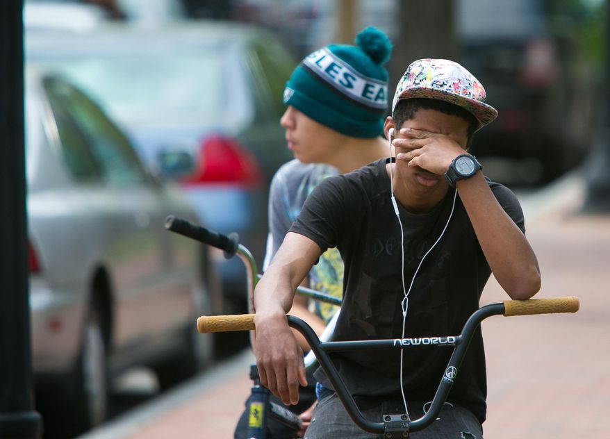 A student cries in front of Howard High School of Technology on Thursday, April 21, 2016 in Wilmington, Del. A 16-year-old sophomore died Thursday following a fight in a Delaware high school girl's restroom, city officials said. (Suchat Pederson/The Wilmington News-Journal via AP) NO SALES; MANDATORY CREDIT