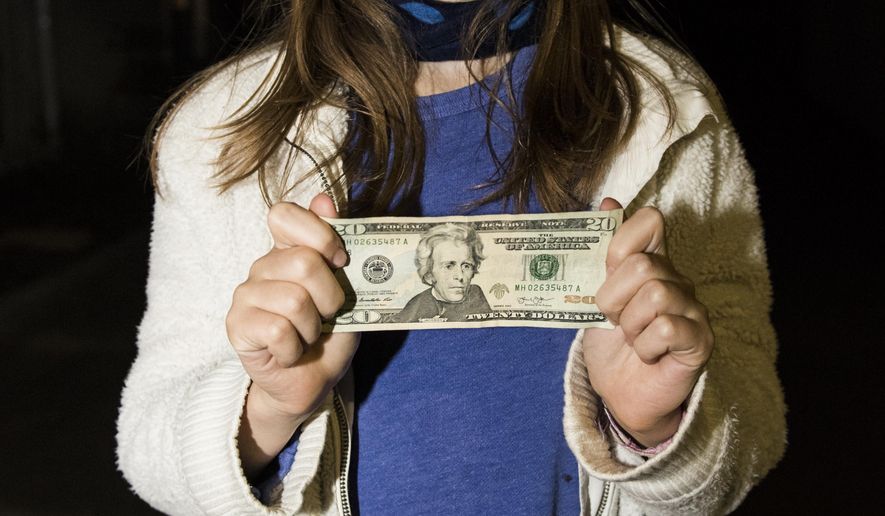 In this Wednesday, April 20, 2016, photo, Sofia, 11, stands with a U.S. $20 bill outside of her home in Cambridge, Mass. Sofia, who wrote a letter to President Barack Obama urging him to put a woman on U.S. paper currency has gotten her wish. Treasury Secretary Jacob Lew announced Wednesday that African-American abolitionist Harriet Tubman will be featured on the front of the $20 bill. (Ryan Mcbride/Boston Herald via AP) BOSTON GLOBE OUT; METRO BOSTON OUT; MAGS OUT; ONLINE OUT; MANDATORY CREDIT
