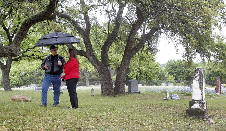 Historic preservation board member Clay Marshall and city administrator Toni Wheeler show where an alien was buried at the cemetery in Aurora, Texas, Wednesday, April 13, 2016. (Khampha Bouaphanh/Star-Telegram via AP)