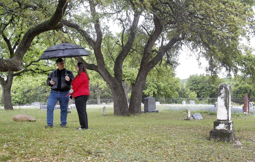 Historic preservation board member Clay Marshall and city administrator Toni Wheeler show where an alien was buried at the cemetery in Aurora, Texas, Wednesday, April 13, 2016. (Khampha Bouaphanh/Star-Telegram via AP)