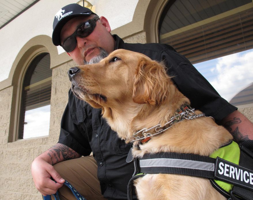 An Army veteran sits with his service dog in Fayetteville, N.C., March 24, 2016. The Department of Veterans Affairs is in the middle of a multi-year study to determine whether it should pay for such psychiatric service dogs. (AP Photo/Allen G. Breed) ** FILE **