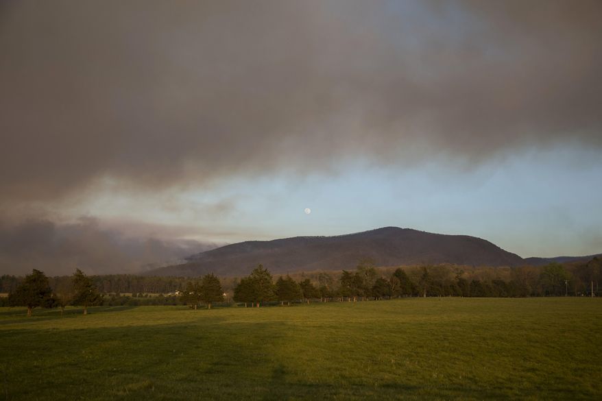 In this Wednesday, April 20, 2016 photo, smoke fills the sky as a forest fire burns in the Shenandoah National Park near Elkton, Va. Crews with the Virginia Department of Forestry worked Wednesday to contain the wildfire. (Michelle Mitchell/News-Virginian via AP) MANDATORY CREDIT