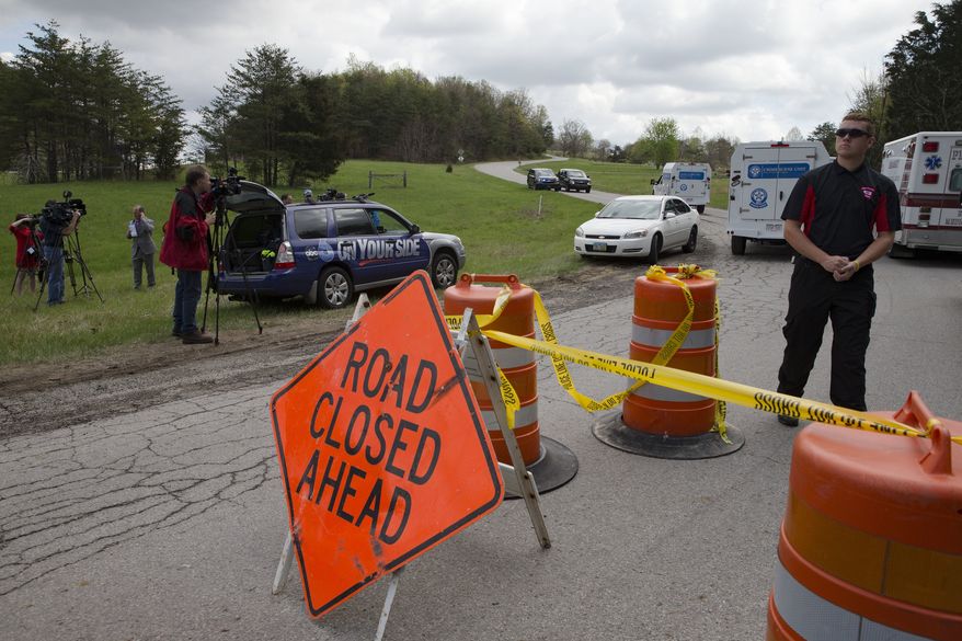 Media and emergency personnel stand at the perimeter of a crime scene as investigation vehicles drive up Union Hill Road, Friday, April 22, 2016, in Pike County, Ohio. Shootings with multiple fatalities were reported along a road in rural Ohio on Friday morning, but details on the number of deaths and the whereabouts of the suspect or suspects weren't immediately clear. The attorney general's office said a dozen Bureau of Criminal Investigation agents had been called to Pike County, an economically struggling area in the Appalachian region some 80 miles east of Cincinnati. (AP Photo/John Minchillo)