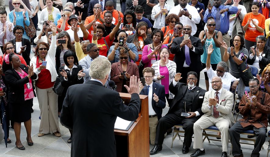 The crowd cheers during Gov. Terry McAuliffe's announcement on the restoration of rights to felons in Virginia at the Capitol in Richmond Va., Friday, April 22, 2016. More than 200,000 convicted felons will be able to cast ballots in the swing state of Virginia in November's election under a sweeping executive order by McAuliffe announced Friday that restores their rights to vote and run for office. (Mark Gormus /Richmond Times-Dispatch via AP) MANDATORY CREDIT