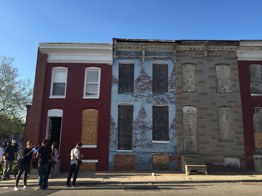 In this April 19, 2016, photo, community activists stand in front of a vacant home that they are transforming into a community center, which sits on a block of derelict buildings in the Sandtown-Winchester neighborhood in Baltimore, Md., just across from where Freddie Gray was arrested. (AP photo/Juliet Linderman)