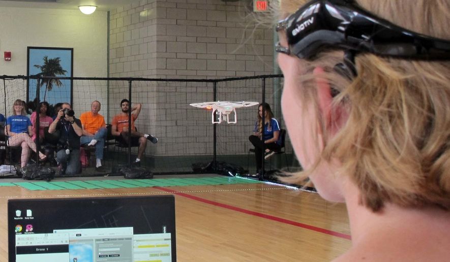 In this April 16, 2016, photo, a University of Florida student uses a brain-controlled interface headset to fly a drone during a mind-controlled drone race in Gainesville, Fla. (AP Photo/ Jason Dearen) **FILE**