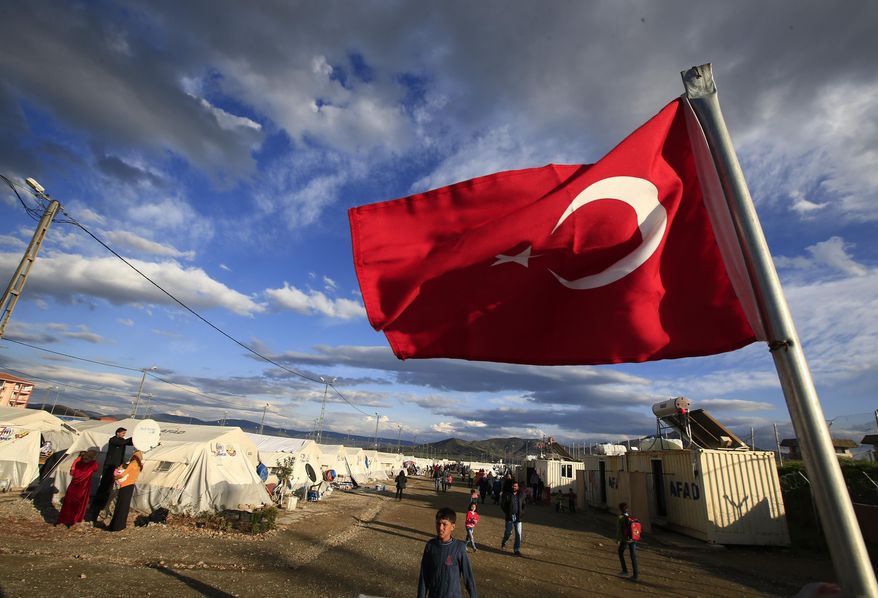 FILE - In this Wednesday, March 16, 2016 file photo a Turkish flag flies at the refugee camp for Syrian refugees in Islahiye, Gaziantep province, southeastern Turkey. German Chancellor Angela Merkel and top European Union officials plan to travel close to Turkey’s border with Syria in hopes of promoting a troubled month-old agreement to manage a refugee crisis that has left hundreds of thousands stranded on the migrant trail to Europe. (AP Photo/Lefteris Pitarakis, File)