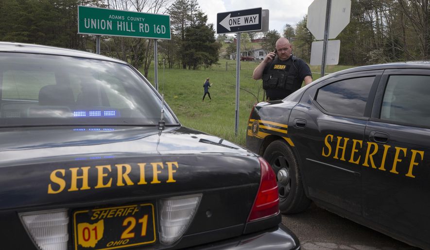 Authorities create a perimeter near a crime scene on Union Hill Rd, Friday, April 22, 2016, in Pike County, Ohio. Shootings with multiple fatalities were reported along a road in rural Ohio on Friday morning, but details on the number of deaths and the whereabouts of the suspect or suspects weren't immediately clear. (AP Photo/John Minchillo)