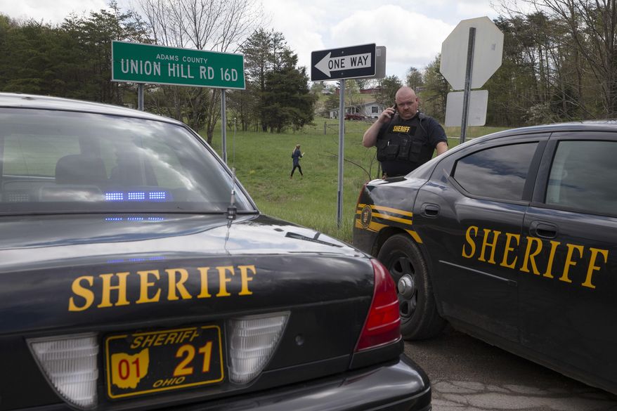 Authorities create a perimeter near a crime scene on Union Hill Rd, Friday, April 22, 2016, in Pike County, Ohio. Shootings with multiple fatalities were reported along a road in rural Ohio on Friday morning, but details on the number of deaths and the whereabouts of the suspect or suspects weren't immediately clear. (AP Photo/John Minchillo)