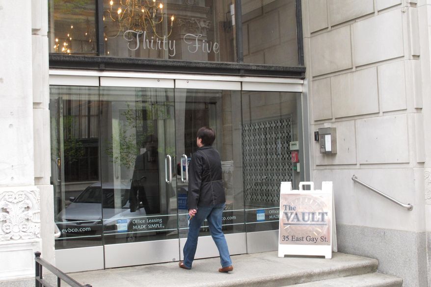 A woman enters the downtown Commerce Building on Thursday, April 21, 2016, in Columbus Ohio. A federal judge ruled in March that property owners can collect rent for the building based on the price of gold as part of a century-old agreement. The decision means rent could jump from $6,000 annually to nearly $350,000. (AP Photo/Andrew Welsh-Huggins)