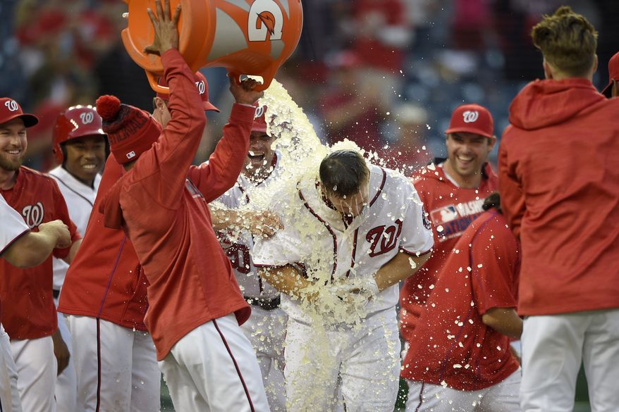 Washington Nationals center fielder Chris Heisey, center, is doused with liquid after he hit a walk off home run during the 16th inning of an interleague baseball game against the Minnesota Twins, Sunday, April 24, 2016, in Washington. The Nationals won 6-5 in 16 innings. (AP Photo/Nick Wass)