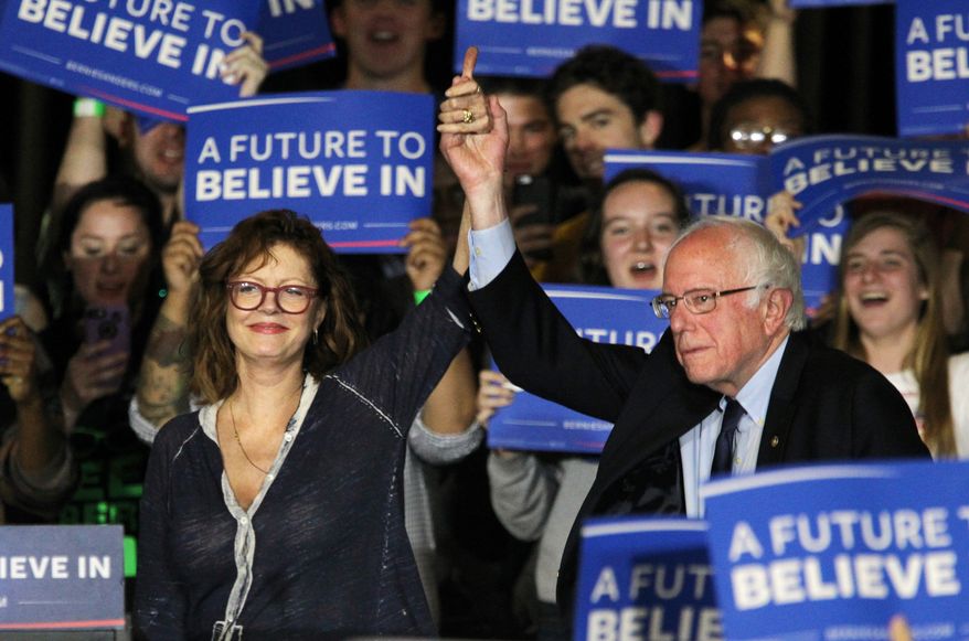The actress Susan Sarandan, left, holds hands with Democratic presidential candidate Bernie Sanders, I-Vt., during a a rally at Drexel University in Philadelphia, Monday, April 25, 2016. (Michael Bryant/The Philadelphia Inquirer via AP)