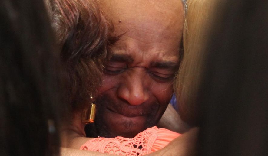 In this photo taken Monday, April 25, 2016, Darryl Pinkins is embraced by family in the lobby of the Lake County Jail in Crown Pointe, Ind., after he was released after serving more than two decades in prison for a gang rape in which he was recently cleared. (Tony V. Martin/The Times via AP) MANDATORY CREDIT; CHICAGO LOCALS OUT; GARY OUT