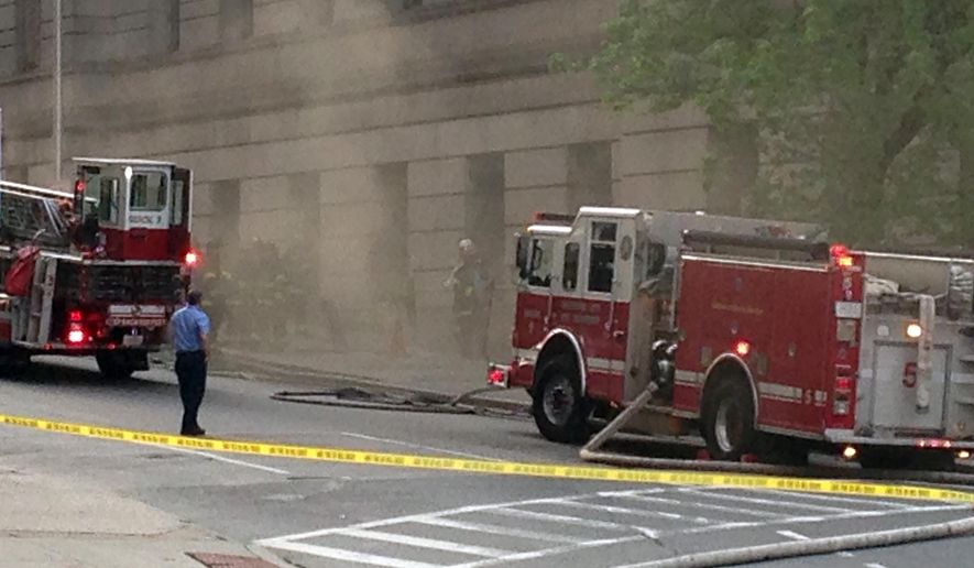 Emergency personal respond to a fire in the Mitchell Courthouse in downtown Baltimore, which forced evacuation of the building Tuesday, April 26, 2016. Fire Department spokesman Capt. Roman Clark said by phone that what little fire that was outside the west building was quickly extinguished. (AP Photo/Brian Witte)