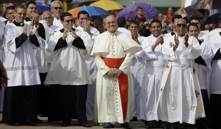 FILE - In this Sept. 4, 2011 file photo, Cuba's Cardinal Jaime Ortega, center, smiles as he waits for the Virgin of the Copper Charity during a procession in Madruga, Cuba. Ortega, who oversaw a warming of relations with the Communist government and played a role in the secret negotiations that led to U.S.-Cuba detente, has stepped down, the Vatican said on Tuesday, April 26, 2016. (AP Photo/Javier Galeano, File)