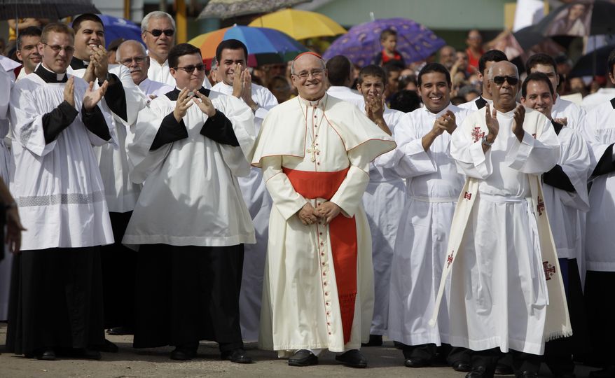 FILE - In this Sept. 4, 2011 file photo, Cuba's Cardinal Jaime Ortega, center, smiles as he waits for the Virgin of the Copper Charity during a procession in Madruga, Cuba. Ortega, who oversaw a warming of relations with the Communist government and played a role in the secret negotiations that led to U.S.-Cuba detente, has stepped down, the Vatican said on Tuesday, April 26, 2016. (AP Photo/Javier Galeano, File)